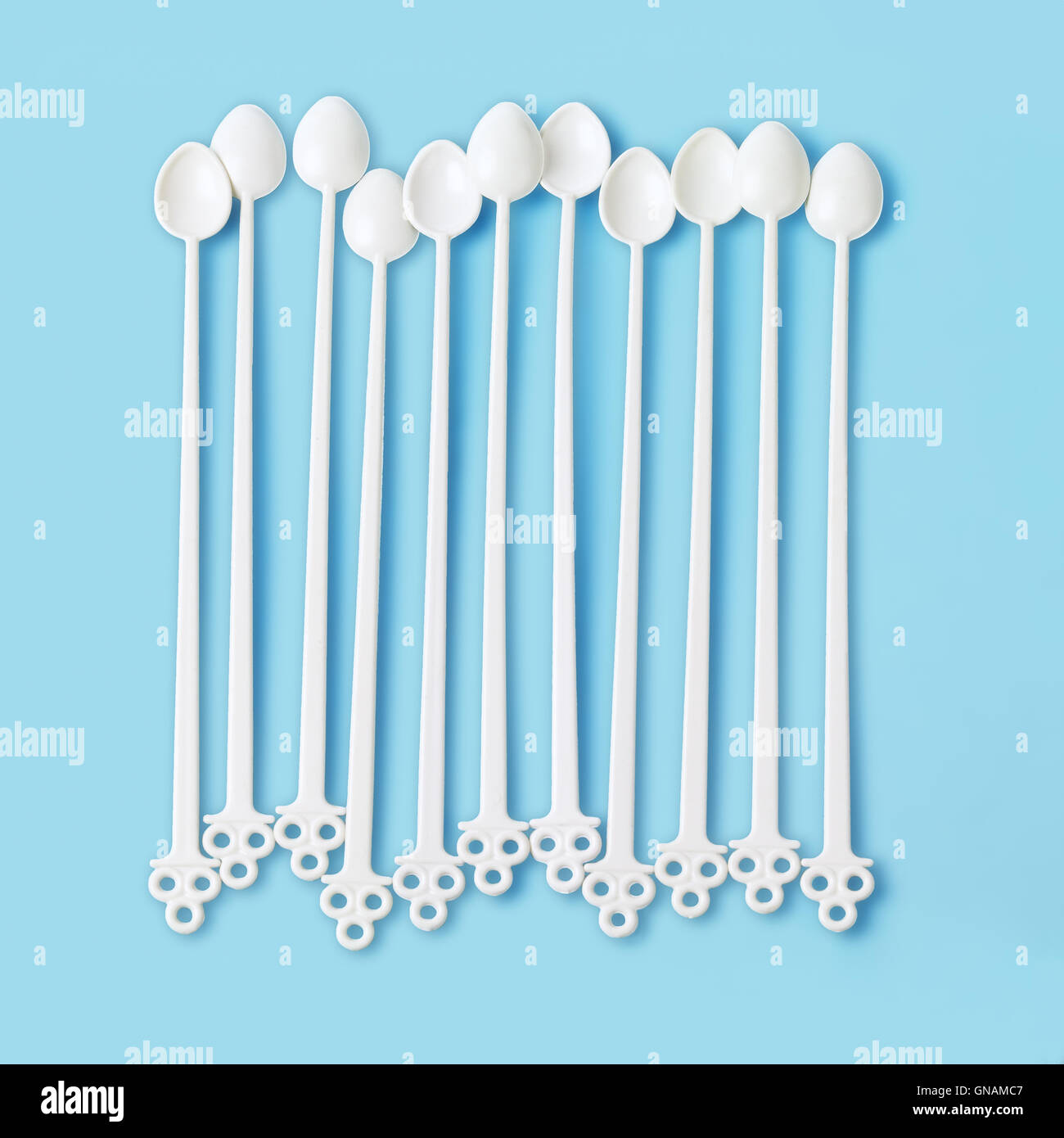 Row of Disposable Plastic Stirrers on Blue Background Stock Photo