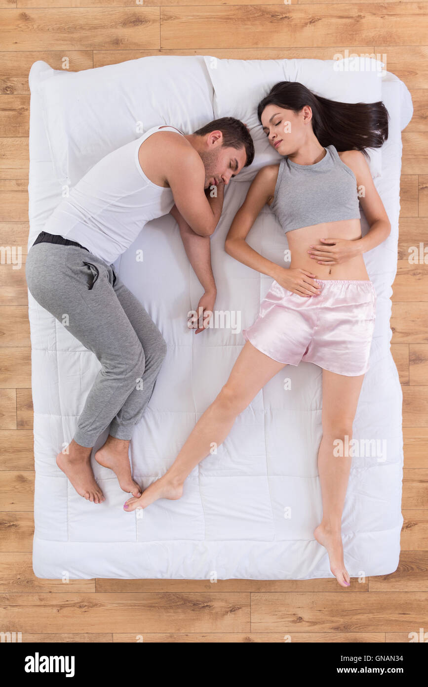 Beautiful man and woman sleeping together in bed Stock Photo
