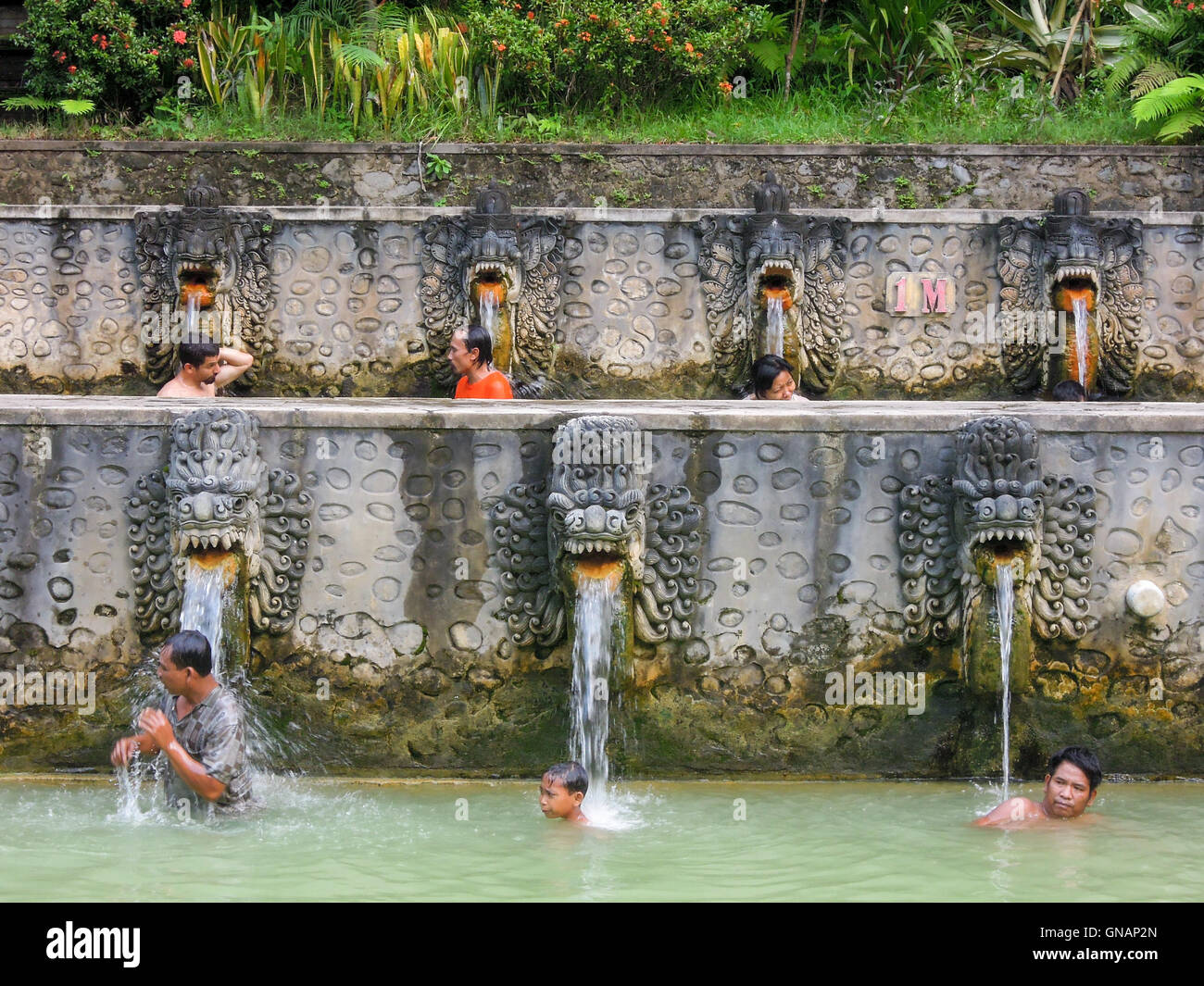 Banjar (Bali), Indonesia - 8 february 2013: People under the water jets of  the public pool at Banjar on the island of Bali, Indo Stock Photo - Alamy