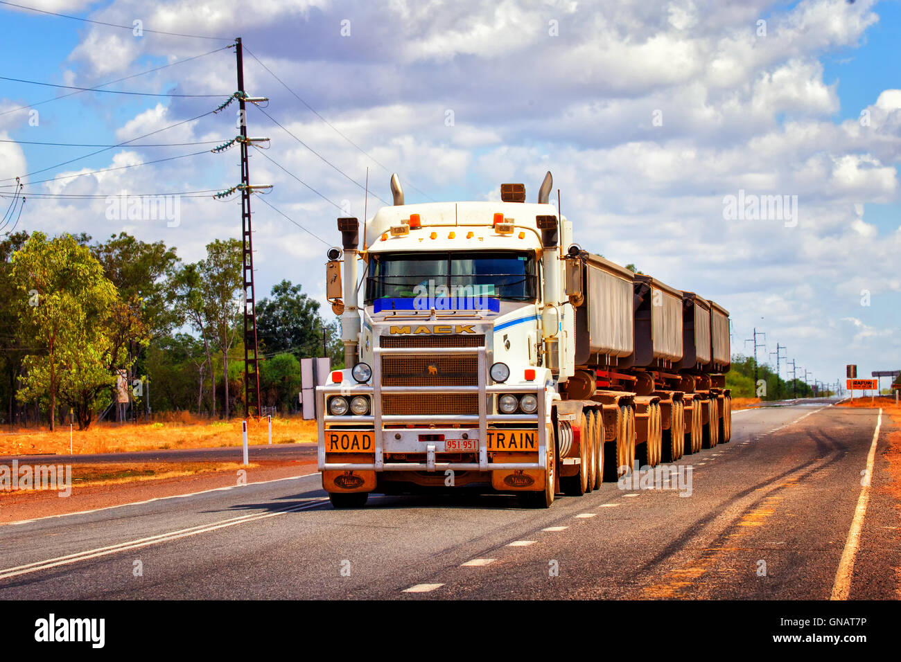 A huge road train travels along the Arnhem Highway in the Australian outback. Stock Photo