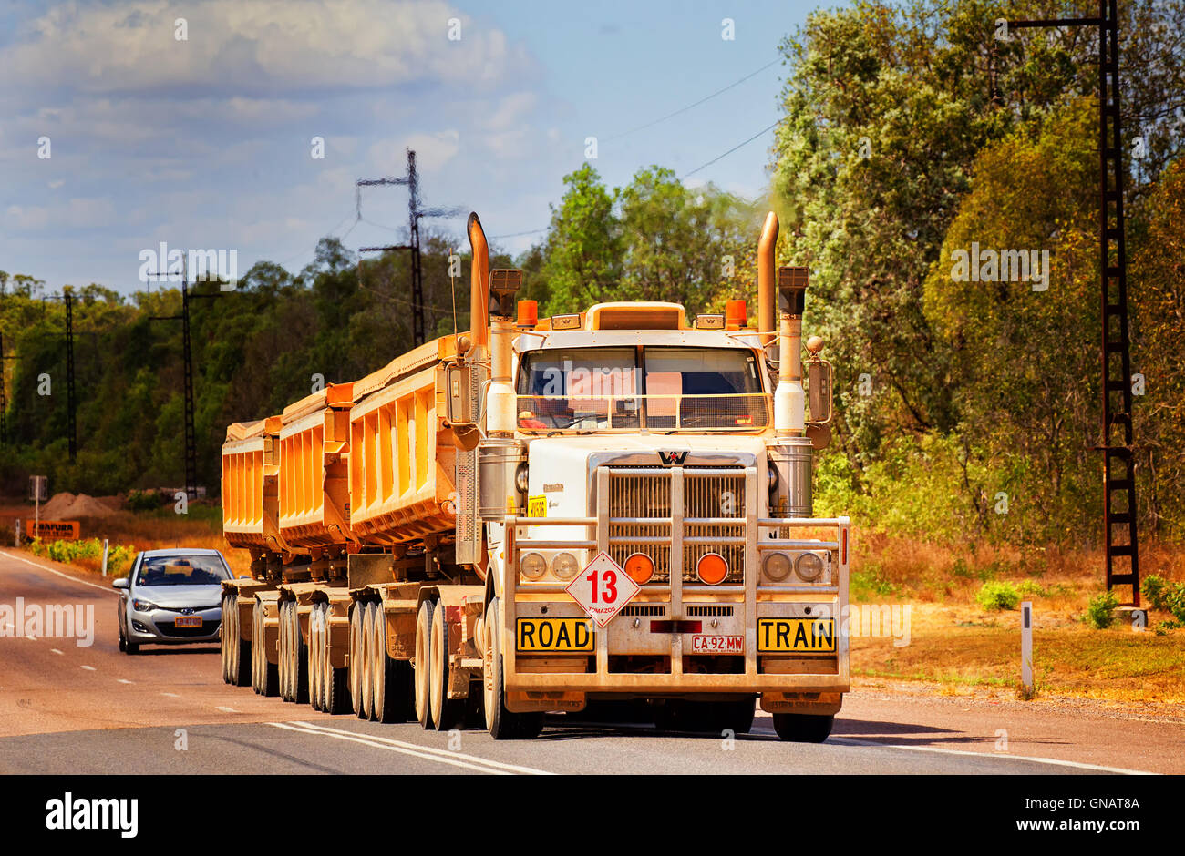 A huge road train travels along the Arnhem Highway in the Australian outback. Stock Photo