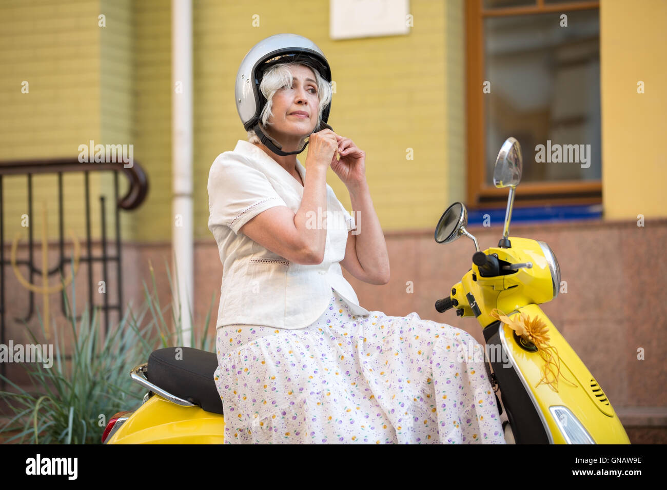 Woman on scooter wearing helmet Stock Photo - Alamy
