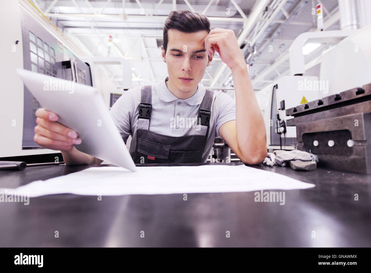 Man working with documents at plant near CNC machines Stock Photo