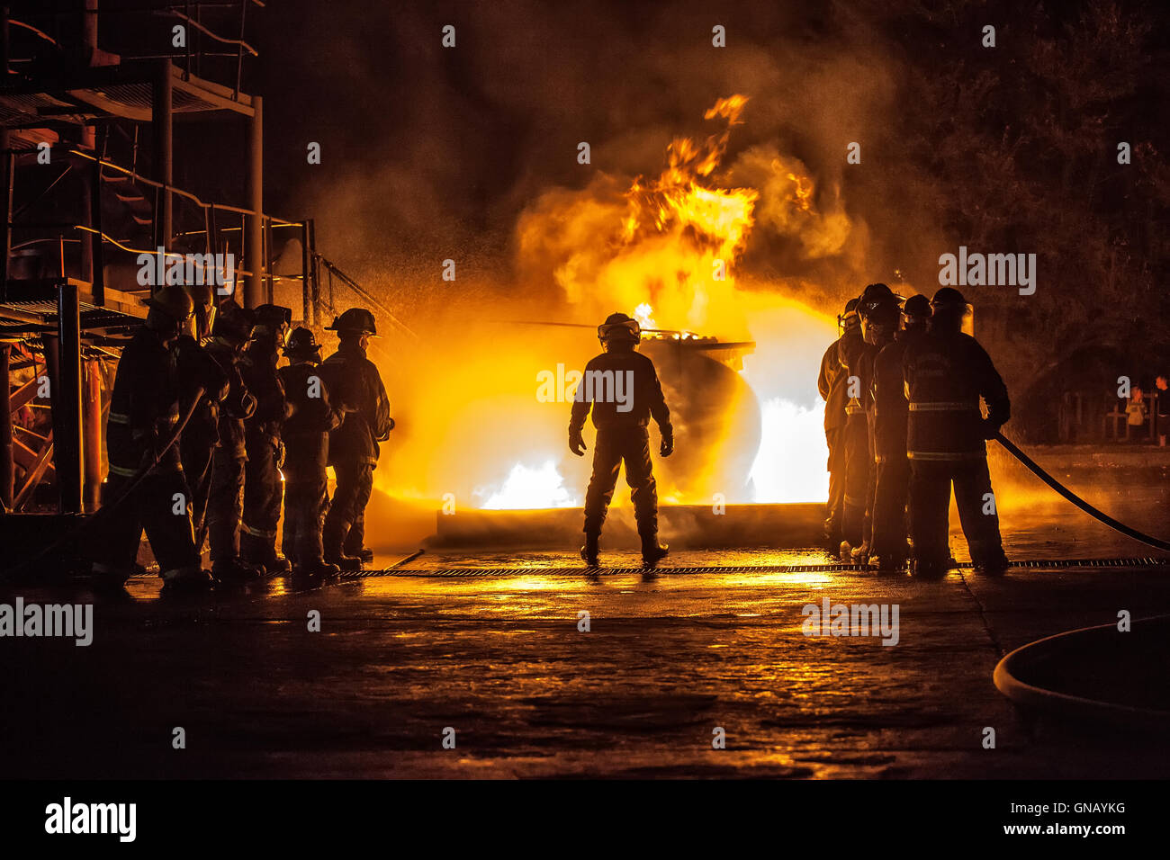 Firechief controlling two teams fighting a fire Stock Photo