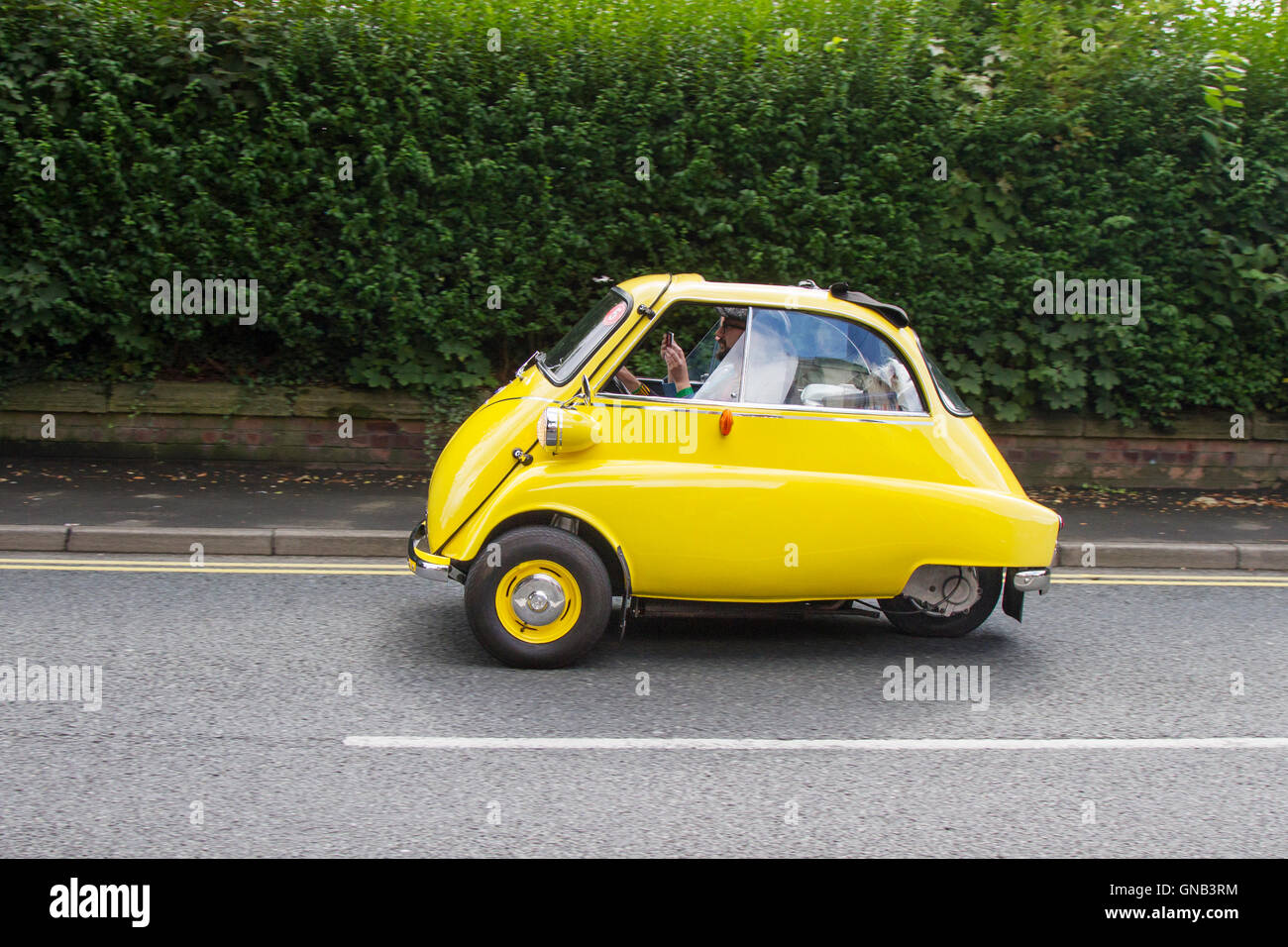 Yellow Isetta 3 wheeler, rare, egg-shaped cruiser with rounded, bubble-like windows at Ormskirk MotorFest with classic veteran bubble cars in the historic town centre, in Lancashire, UK Stock Photo
