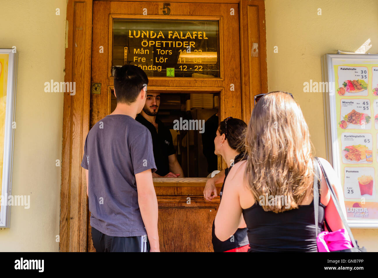 Lund, Sweden - August 24, 2016: People ordering food at Lunda Falafel, a popular fast food place serving food through a hole in Stock Photo
