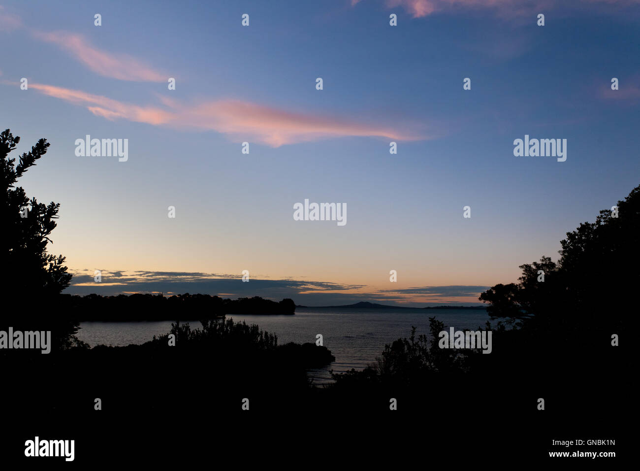 Blue sky sunset clouds over dark coastal landscape Stock Photo - Alamy