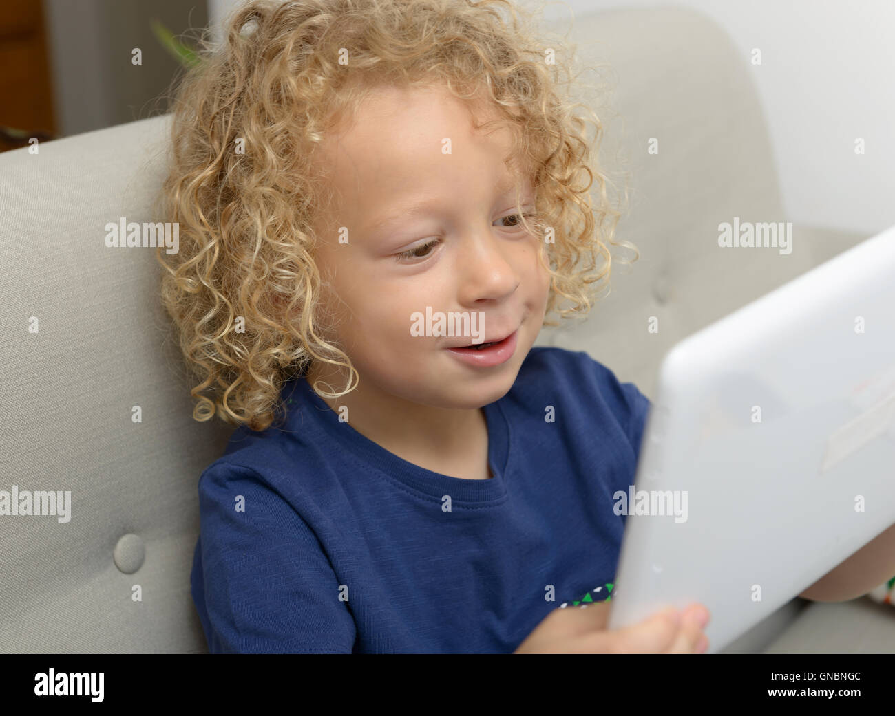 a little blond boy with a digital tablet Stock Photo - Alamy