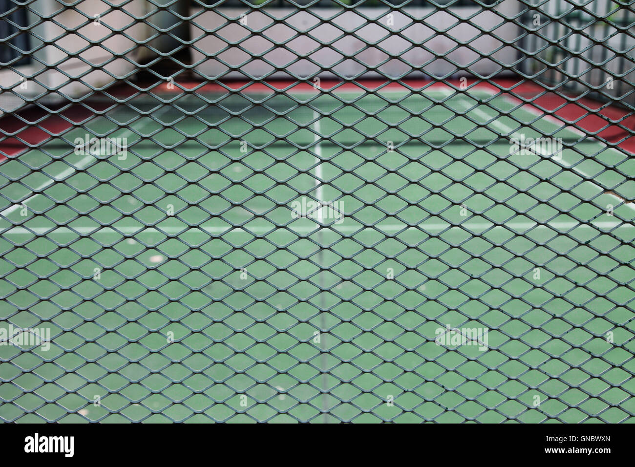 Tennis court behind a grid fence or metal mesh Stock Photo