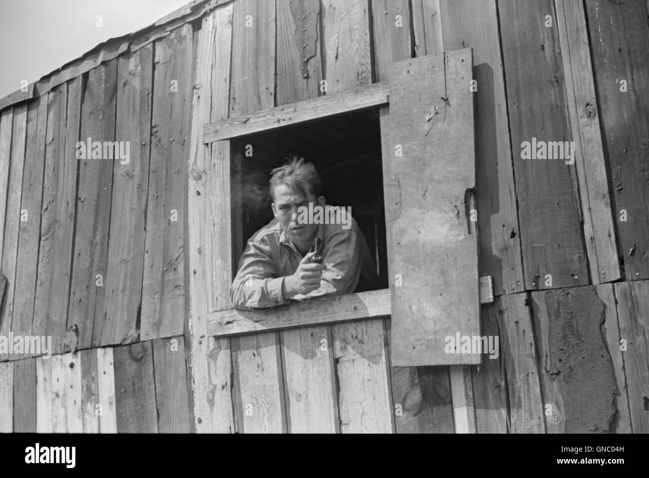 Coal Miner with Pipe Looking out Window of his Home, Bertha Hill, West Virginia, USA, Marion Post Wolcott for Farm Security Administration, September 1938 Stock Photo