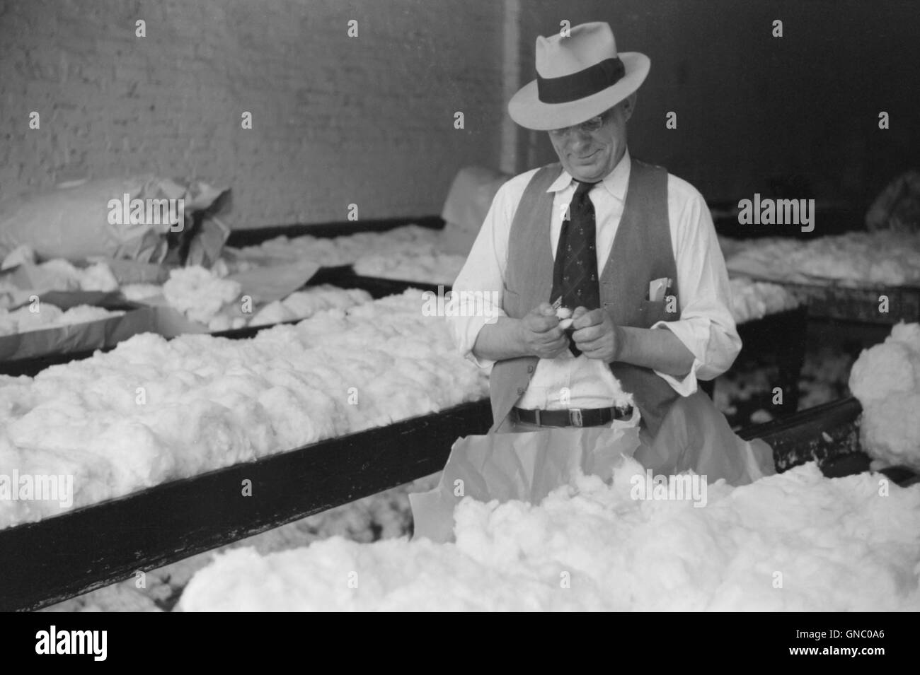 Man sampling cotton in classing room of cotton factory's office