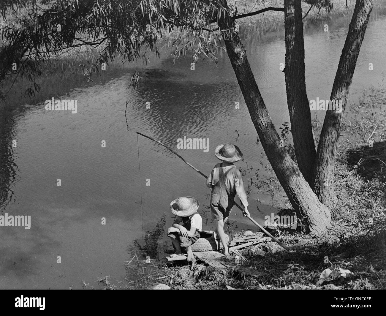 Two Cajun Boys Fishing in Bayou, Schriever, Terrabonne Parish, Louisiana, USA, Marion Post Wolcott for Farm Security Administration, June 1940 Stock Photo
