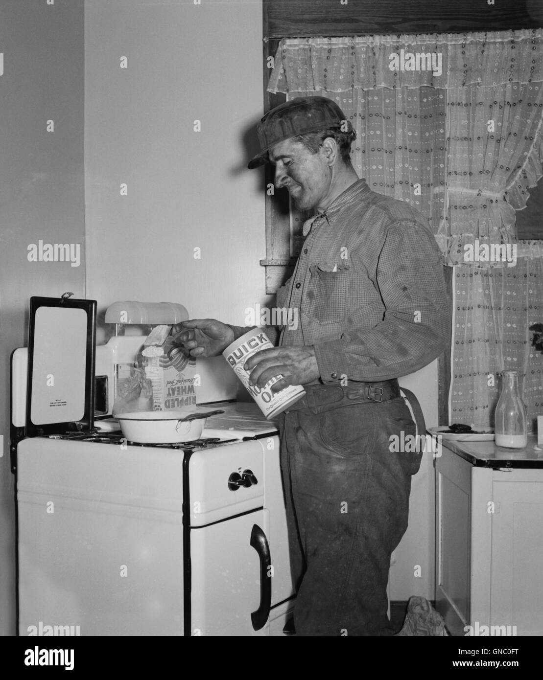 Coal Miner Making Breakfast at Home after Returning from Night Shift Work, Westover, West Virginia, USA, Marion Post Wolcott for Farm Security Administration, September 1938 Stock Photo
