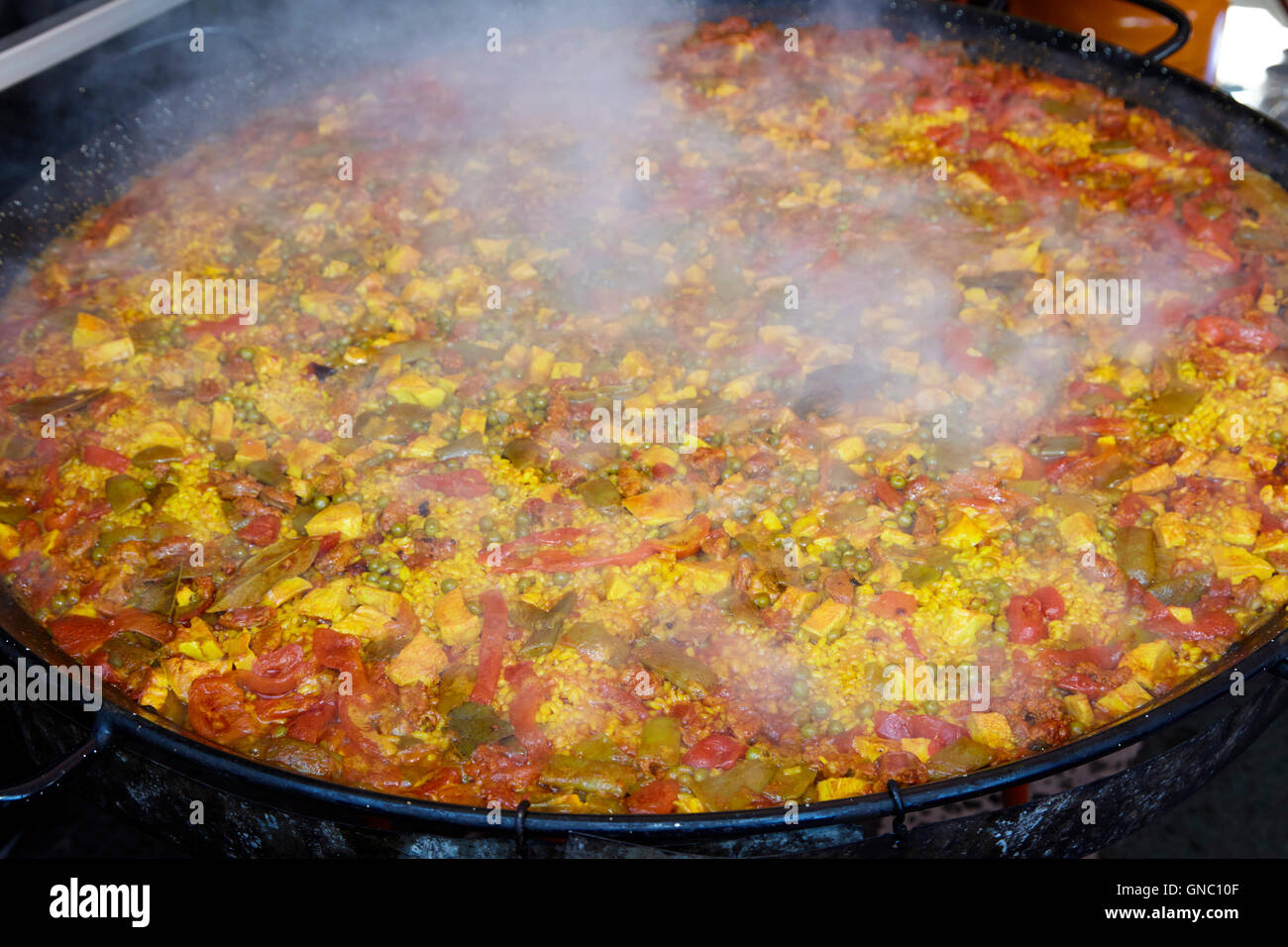 https://c8.alamy.com/comp/GNC10F/large-pan-of-paella-cooking-on-a-commercial-pan-at-a-food-festival-GNC10F.jpg