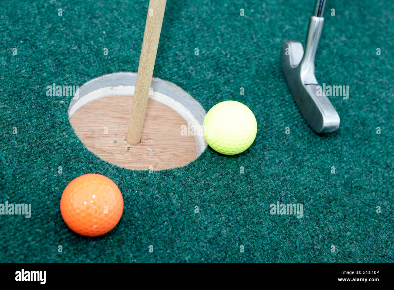 balls and golf putter on home made crazy golf hole Stock Photo