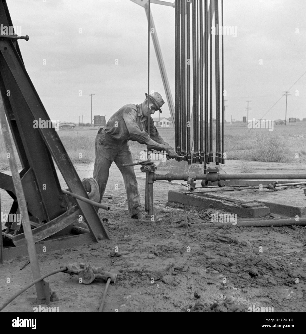 Man Servicing Old Oil Well, near Wichita, Kansas, USA, Marion Post Wolcott for Farm Security Administration, September 1941 Stock Photo
