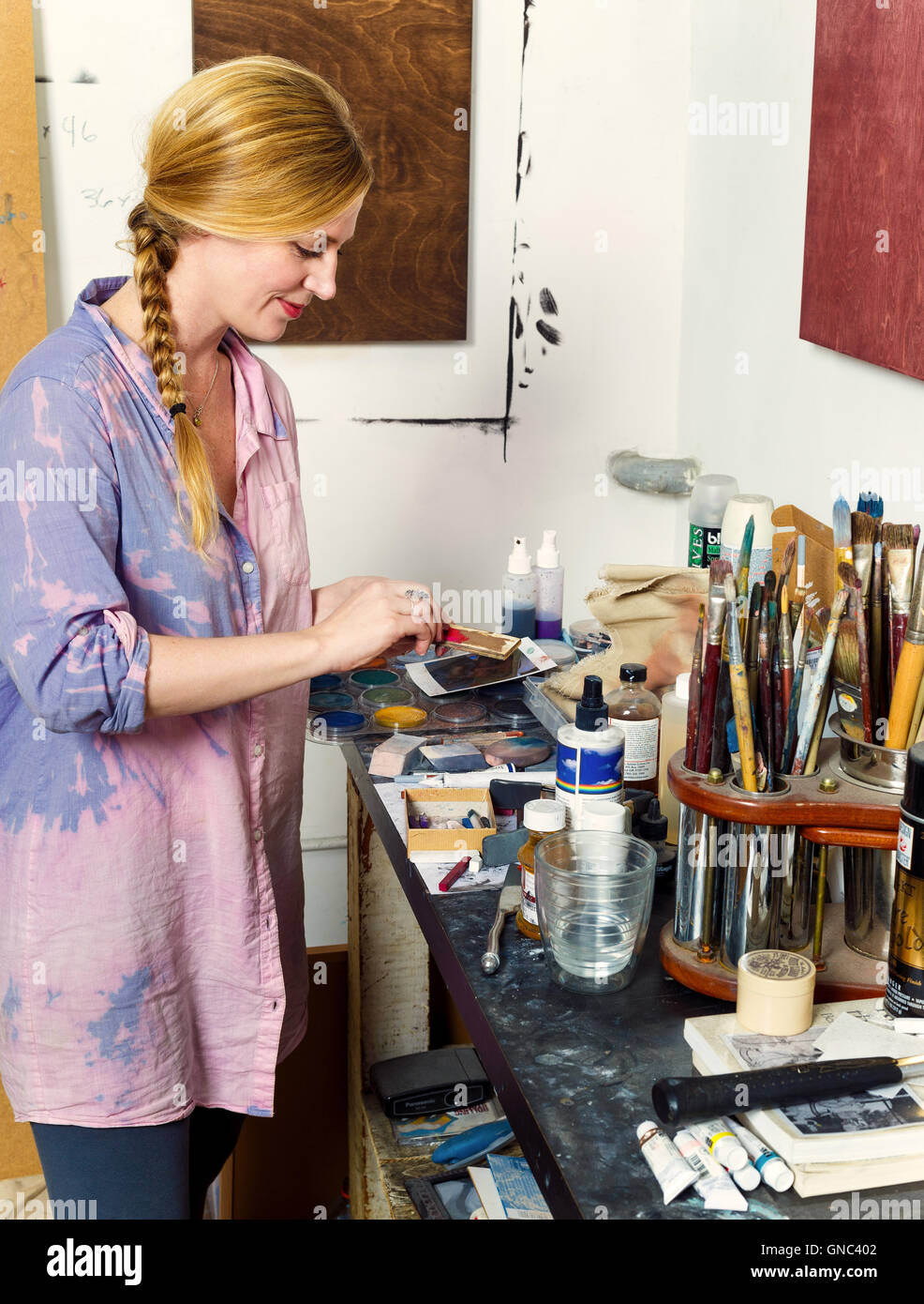 Blonde Woman Mixing Paints in Painter's Studio Stock Photo
