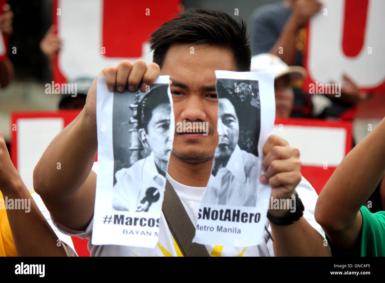 Philippines. 29th Aug, 2016. A protester tear-off the photo of former Pres. Marcos during the protest of Bagong Alyansang Makabayan (BAYAN METRO MANILA) hold rally in front of the Bonifacio Shrine beside Manila City Hall in the time for National Heroes Day to protest the Marcos hero's burial at the Libingan ng mga Bayani. The rally is held few days before the oral argument of the Supreme Court regarding various petitions opposing the Marco's burial. Credit:  Gregorio B. Dantes Jr./Pacific Press/Alamy Live News Stock Photo