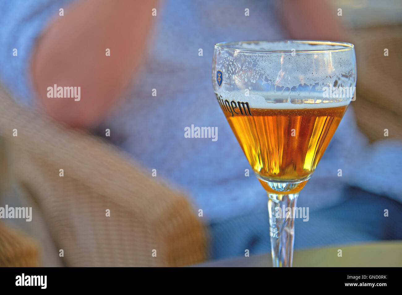Half drunk glass of lager beer in a fluted glass Stock Photo