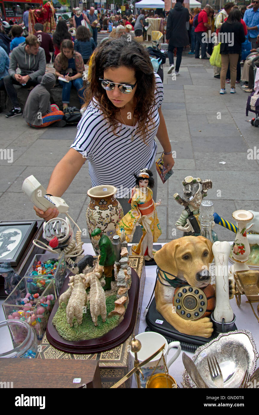 A female visitor to the annual Grassmarket Fair checks out one of the stalls. Stock Photo