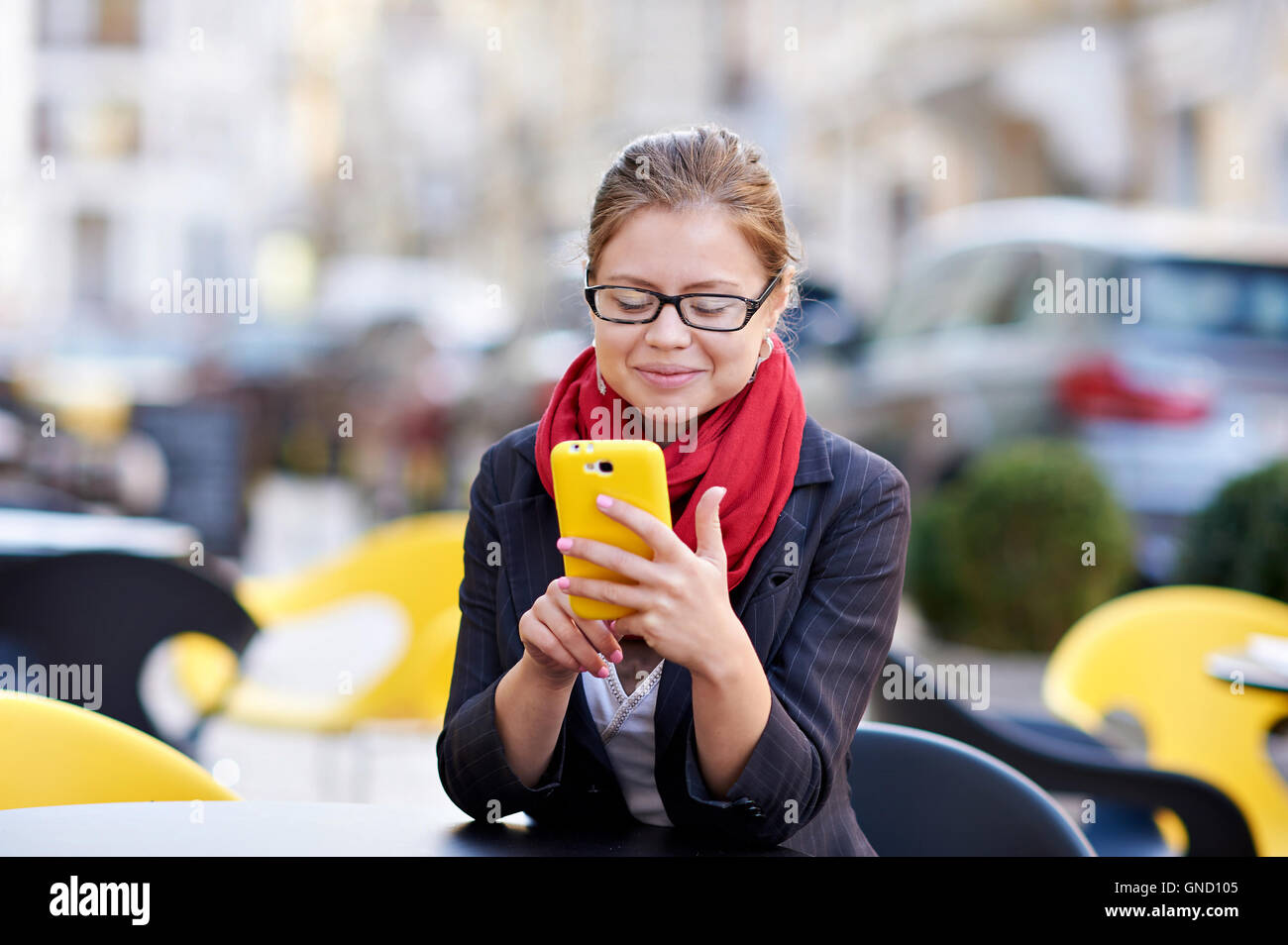 young woman in glasses writes sms on phone Stock Photo
