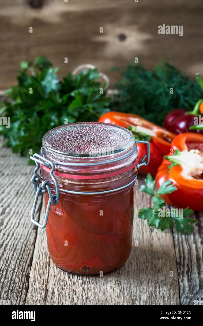 Homemade pickled peppers in tomato juice and sweet bell red pepper on