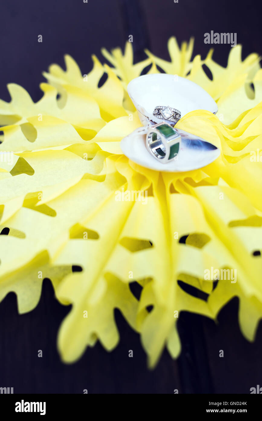 Wedding rings put in shell on yellow star background. Stock Photo