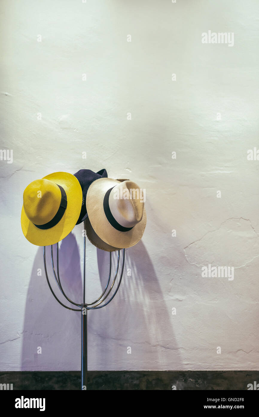 Hats on hanger, white wall background, selective focus. Stock Photo
