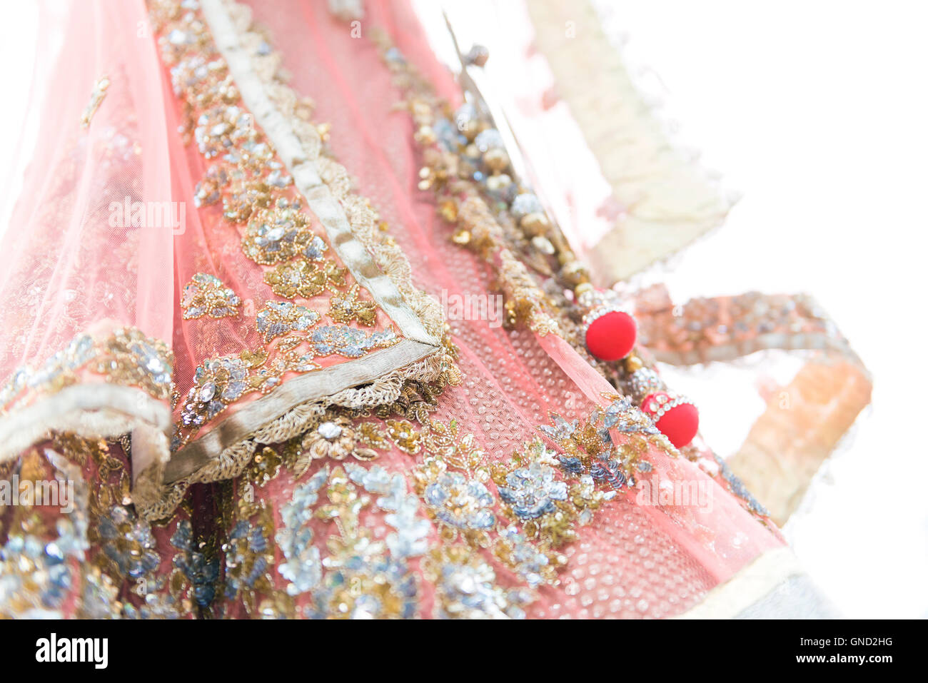 Closeup colourful traditional indian bride dress on white background. Selective focus. Stock Photo