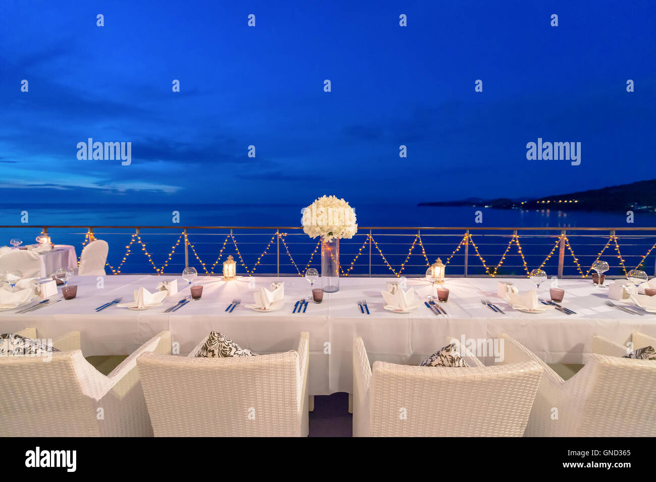 Romantic dinner setup, decoration with candle light. Selective focus. Twilight. Stock Photo