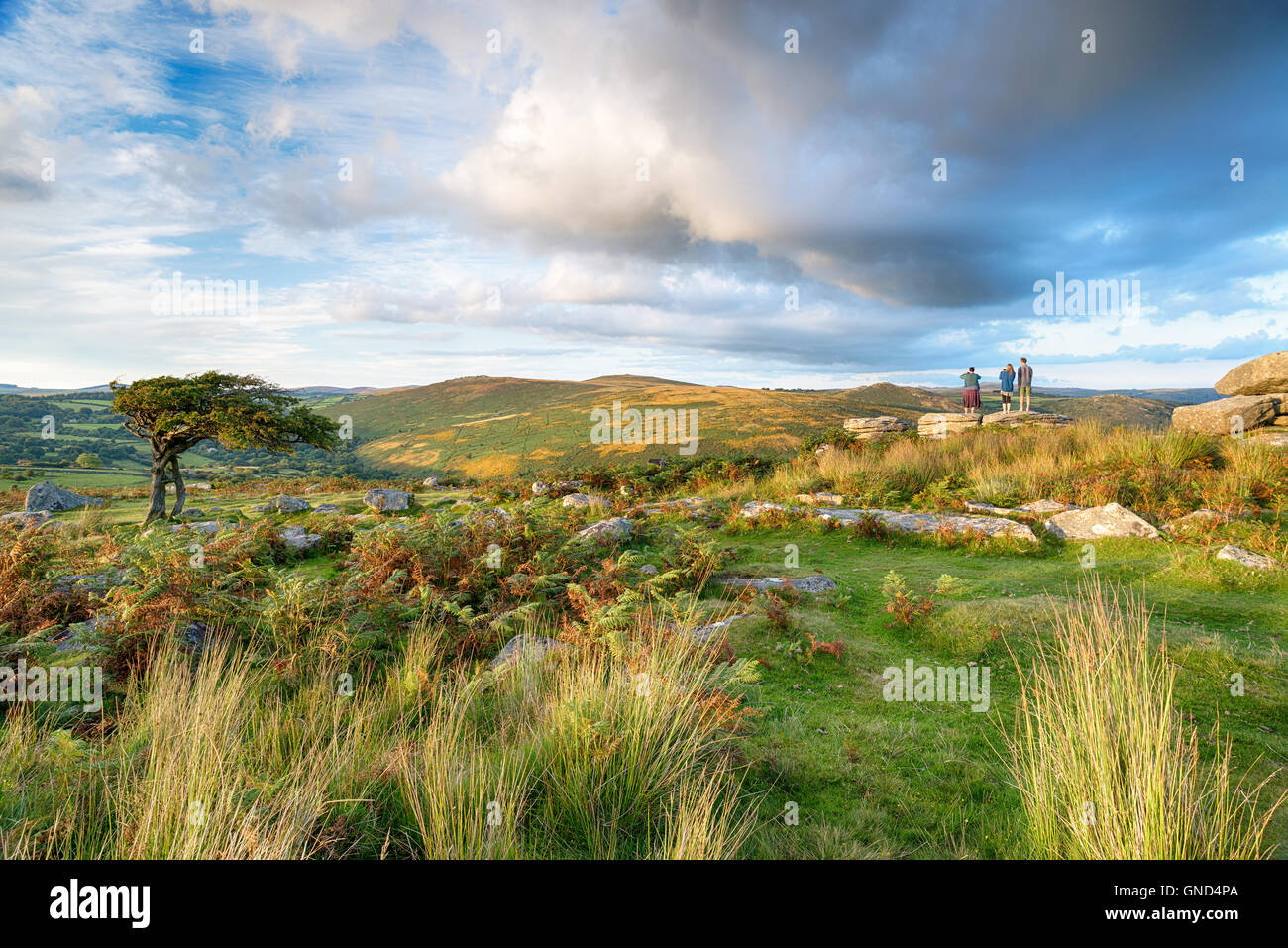 People enjoying the stunning view at combestone Tor on Dartmoor National Park in Devon Stock Photo