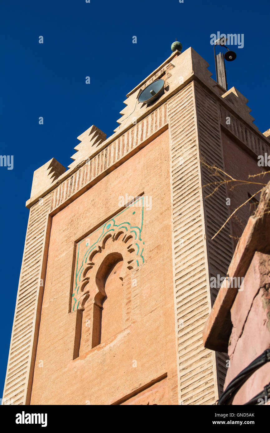 Minaret of one of many mosques in the medina of Marrakesh, enlightened by sun. Traditional architectural details. Bright blue sk Stock Photo
