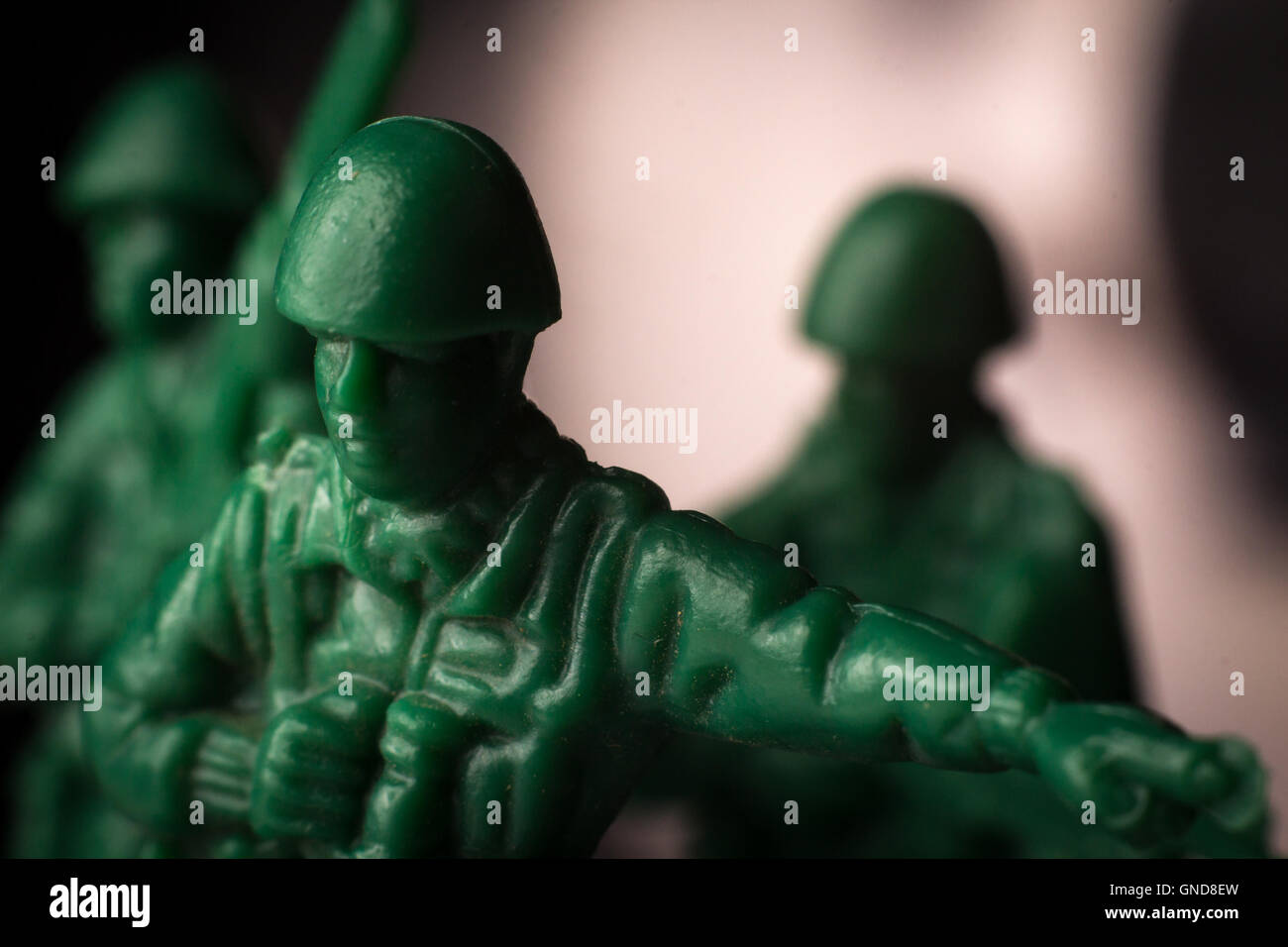 Green toy soldier lookout with binoculars points the way Stock Photo