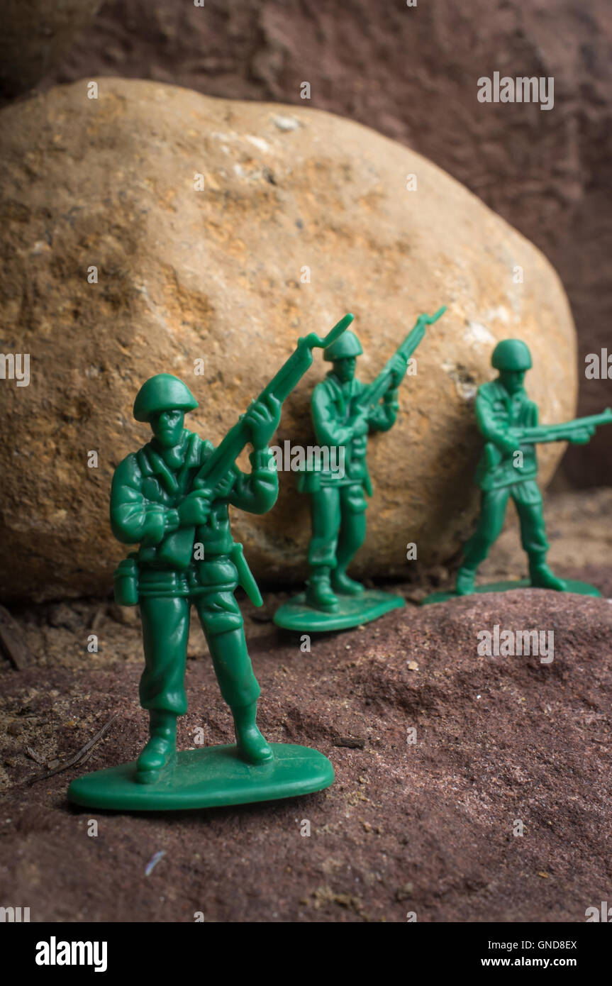 Toy soldiers march along rocky cliffs in natural environment Stock Photo