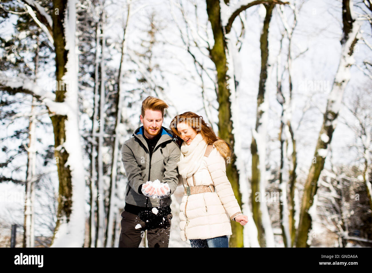 Young couple having fun in the snow in the park Stock Photo