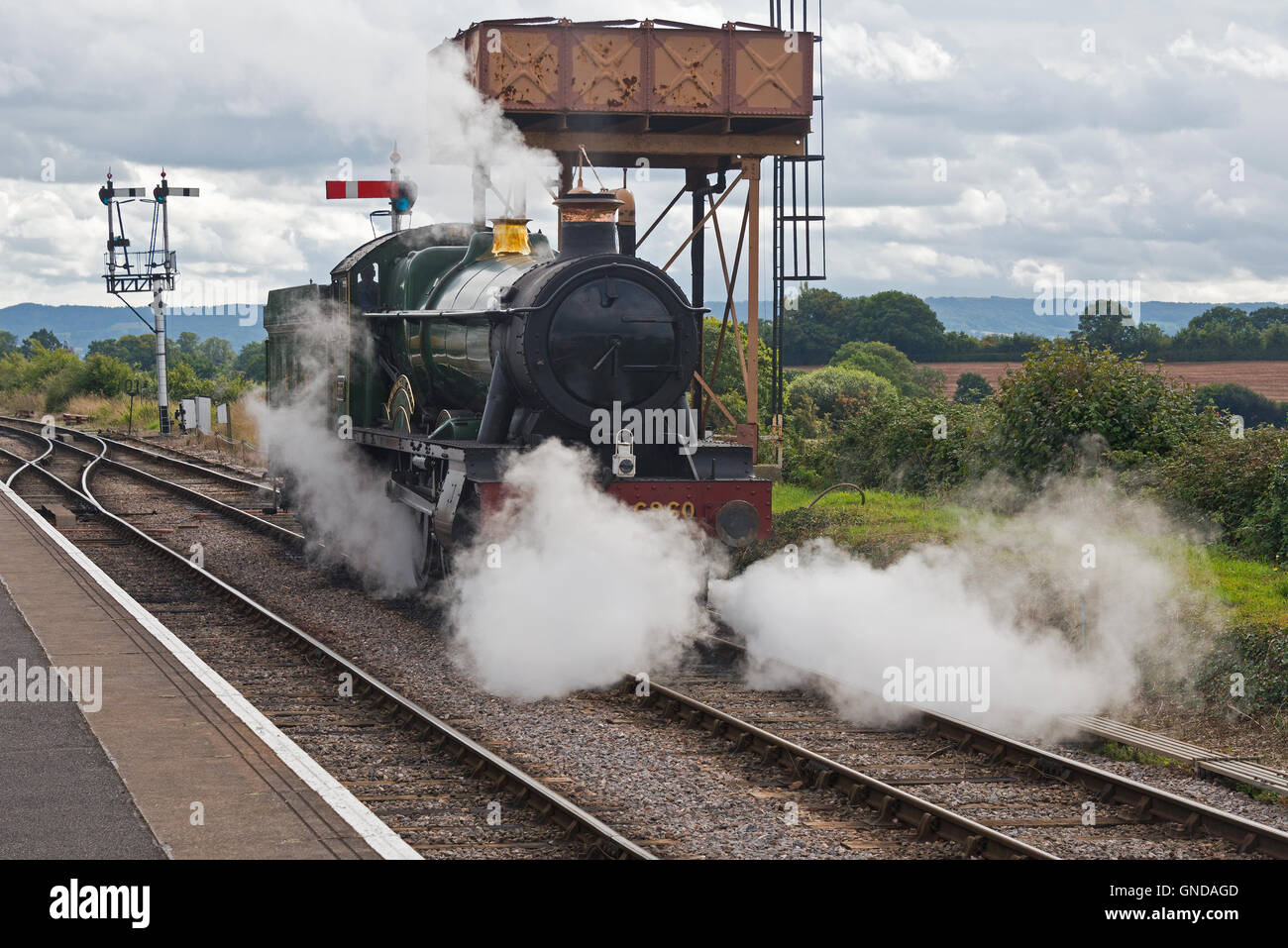 Steam engine 6960 Raveningham Hall preparing to leave the water tower at Bishops Lydeard station on the West Somerset Railway Stock Photo