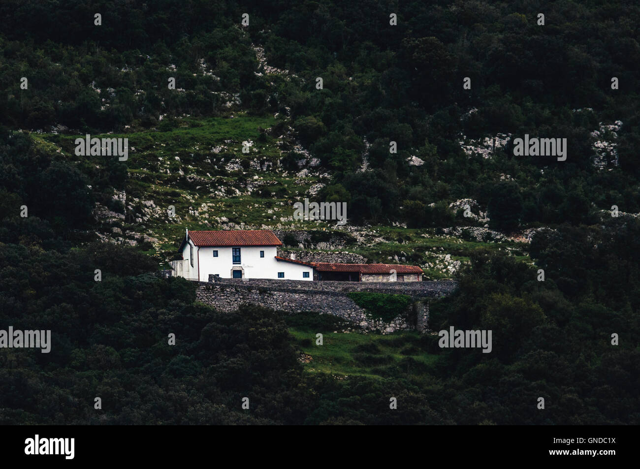 Solitude alone house nestled on the side of a hill in the village of Berria, Santoña, Cantabria, Spain. Stock Photo