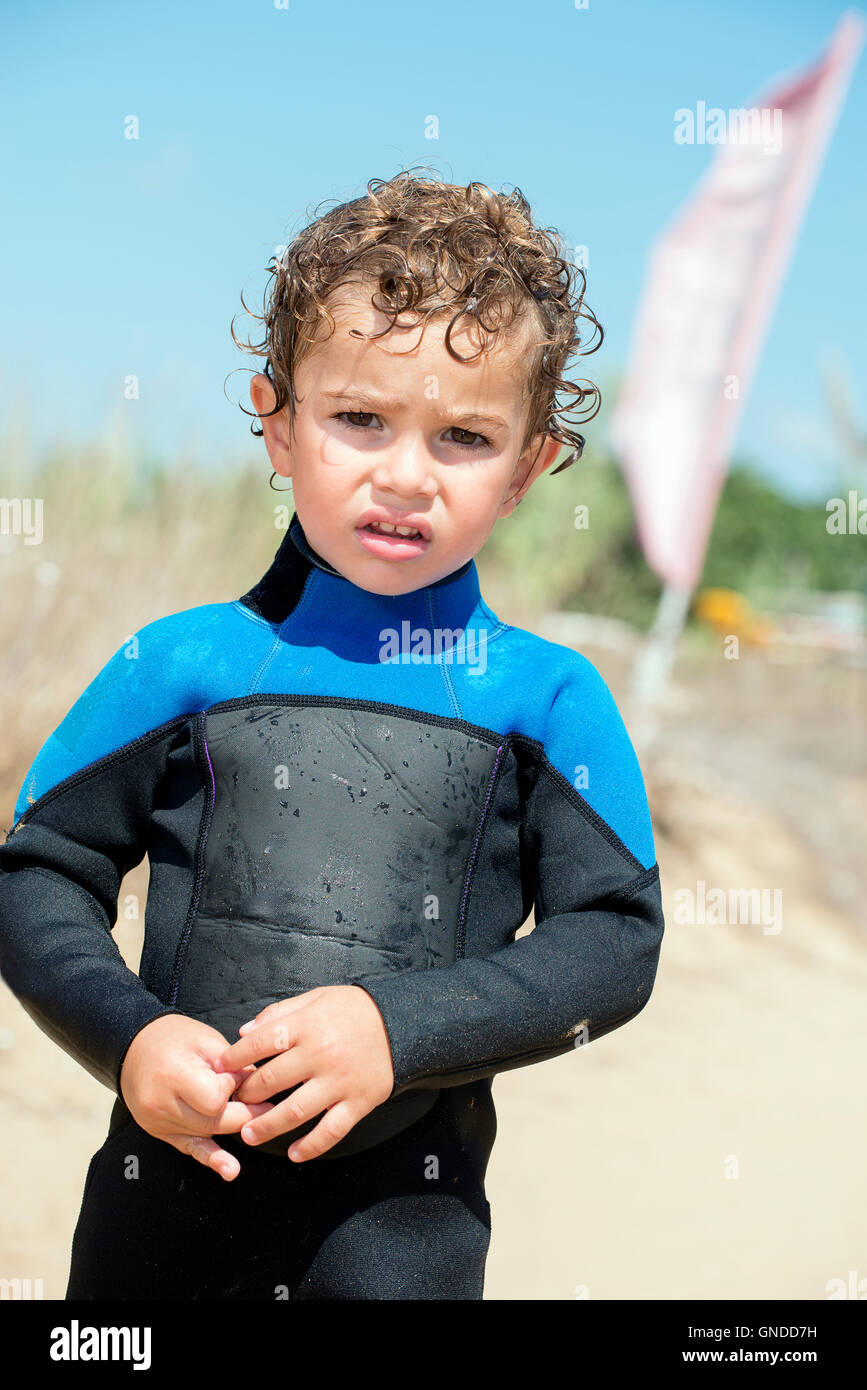 portrait of young boy by a sand beach in diving suit Stock Photo Alamy