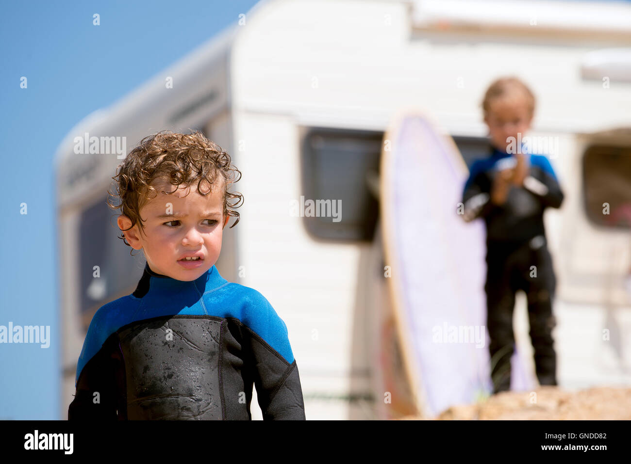 portrait of two youngs boys by the beach in diving suit Stock Photo