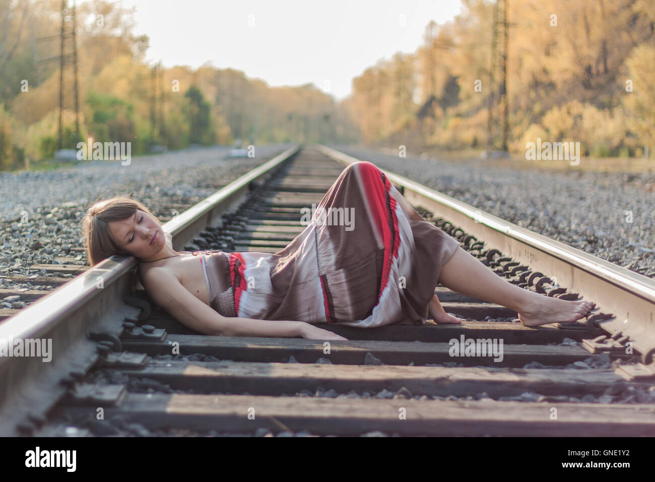 Beautiful girl laying on railroad track Stock Photo Alamy