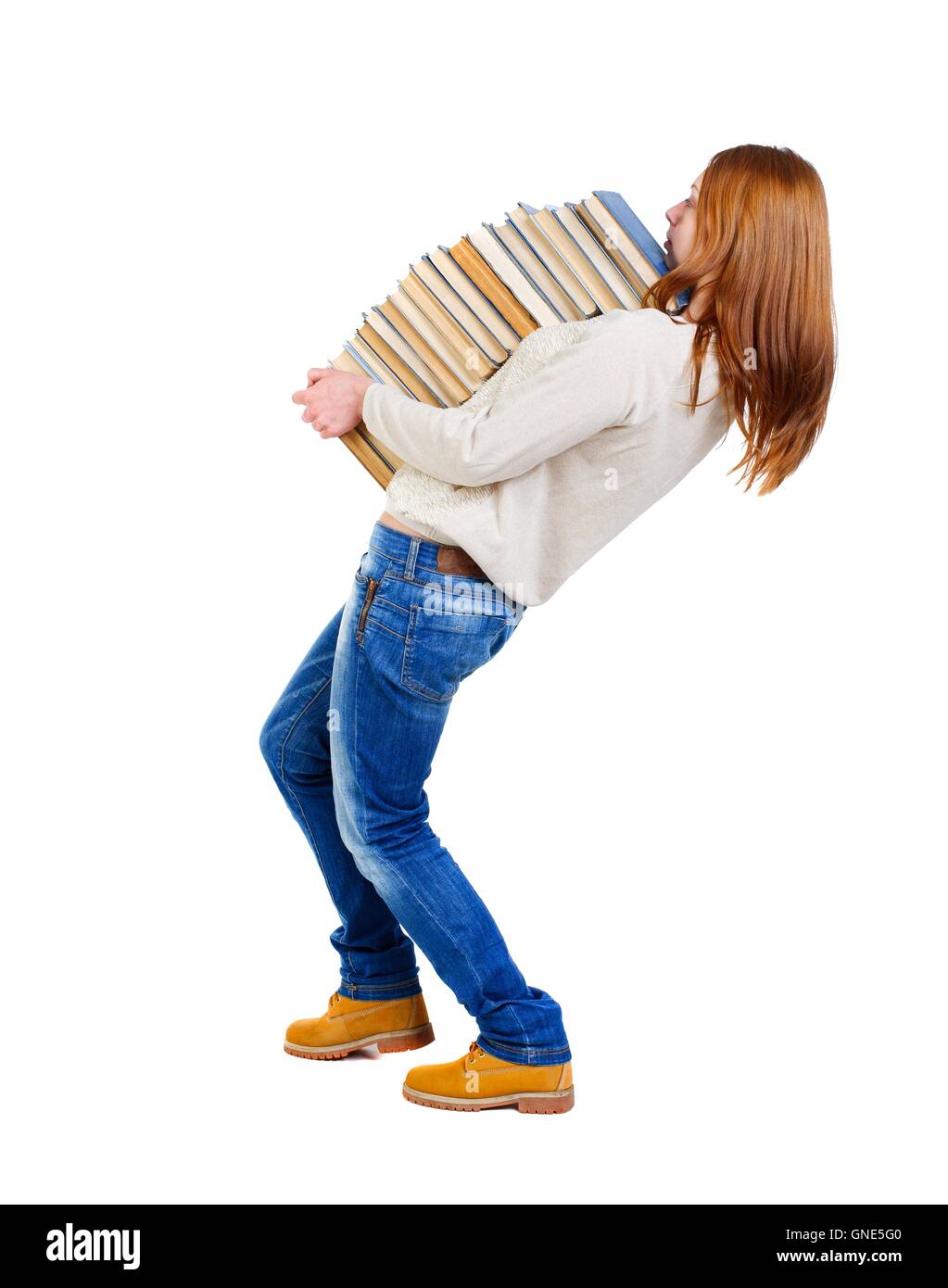 Girl carries a heavy pile of books. back view Stock Photo - Alamy