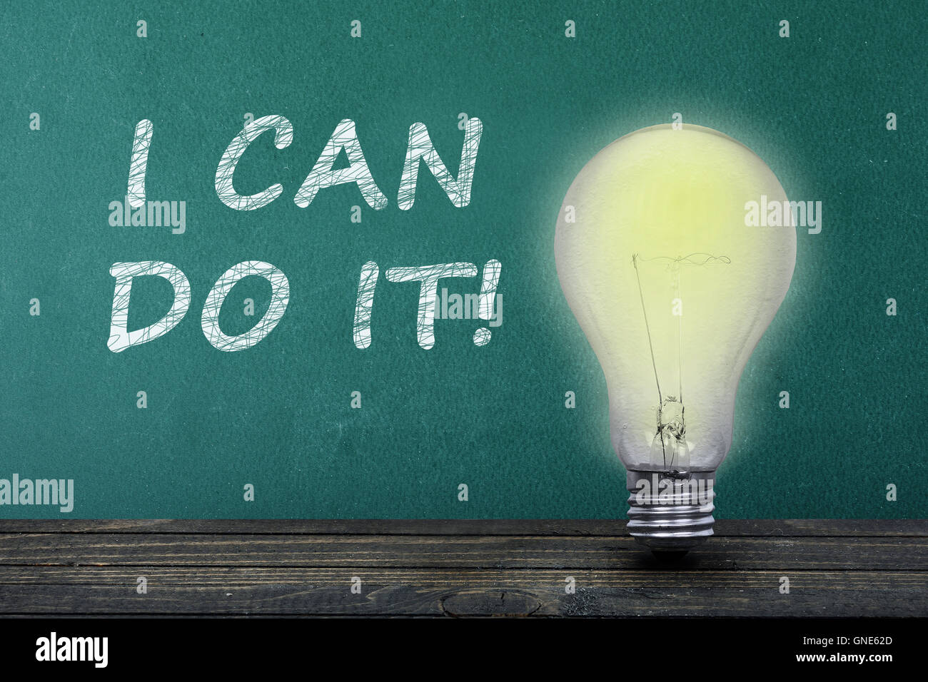 I can do it text on green board and light bulb on table Stock Photo
