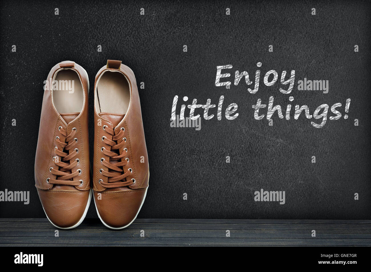 Enjoy little things text on black board and shoes Stock Photo