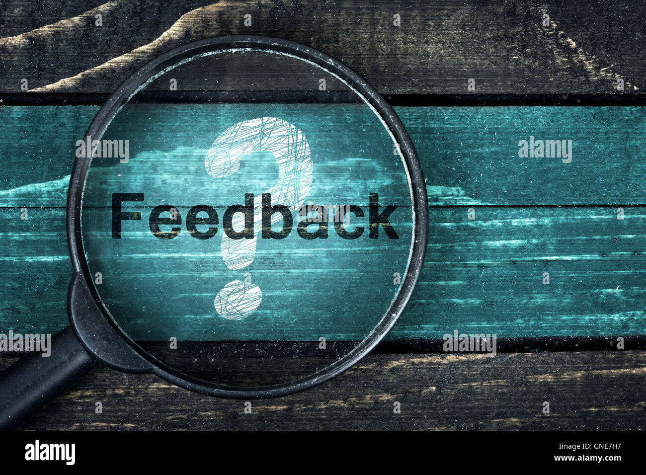 Feedback text painted and magnifying glass on wooden table Stock Photo