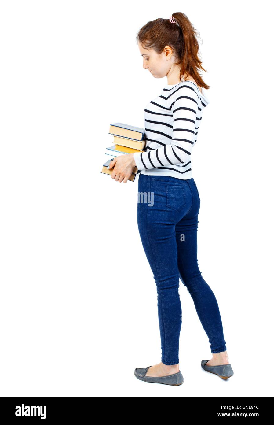 Girl carries a heavy pile of books. back view Stock Photo - Alamy