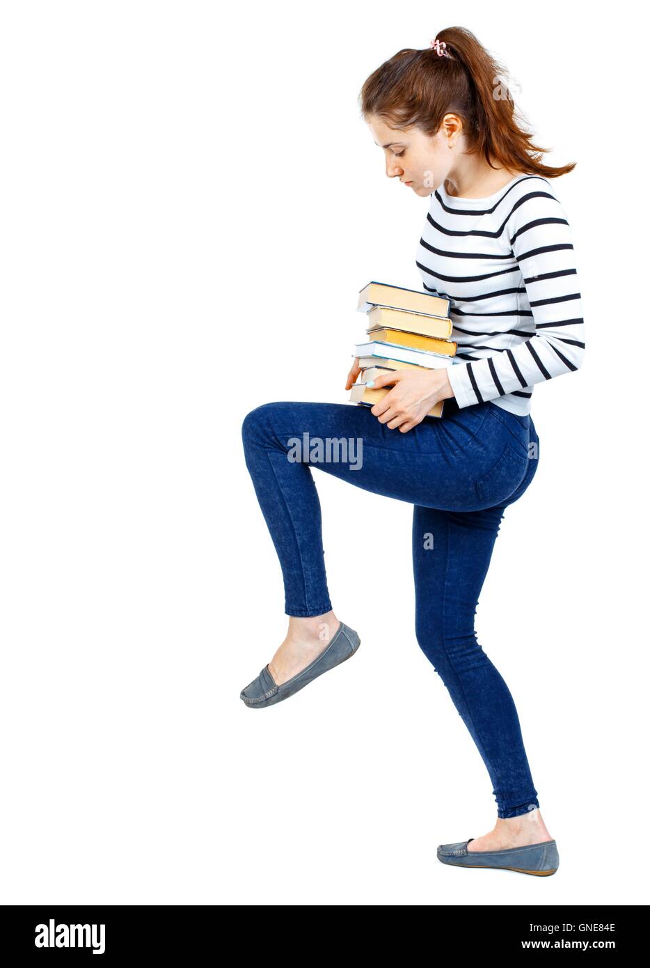 Girl carries a heavy pile of books. back view Stock Photo - Alamy