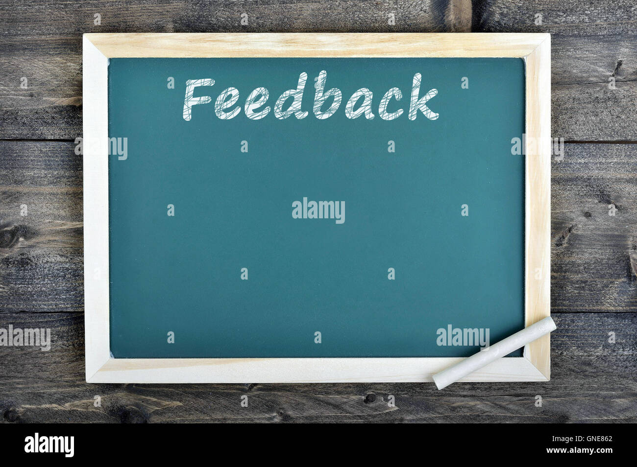 Feedback text on school board and chalk on wooden table Stock Photo