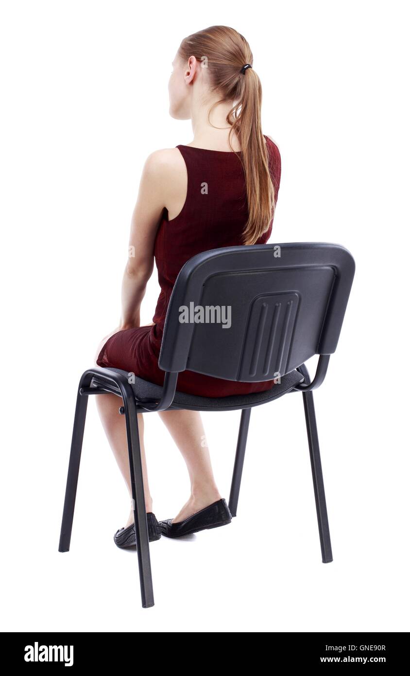 back view of young beautiful  woman sitting on chair. Stock Photo