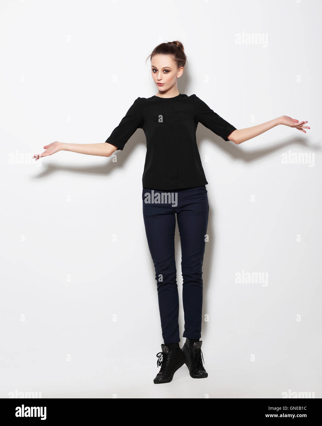 Young girl model posing in the studio full-length. Hands to the side. Stock Photo