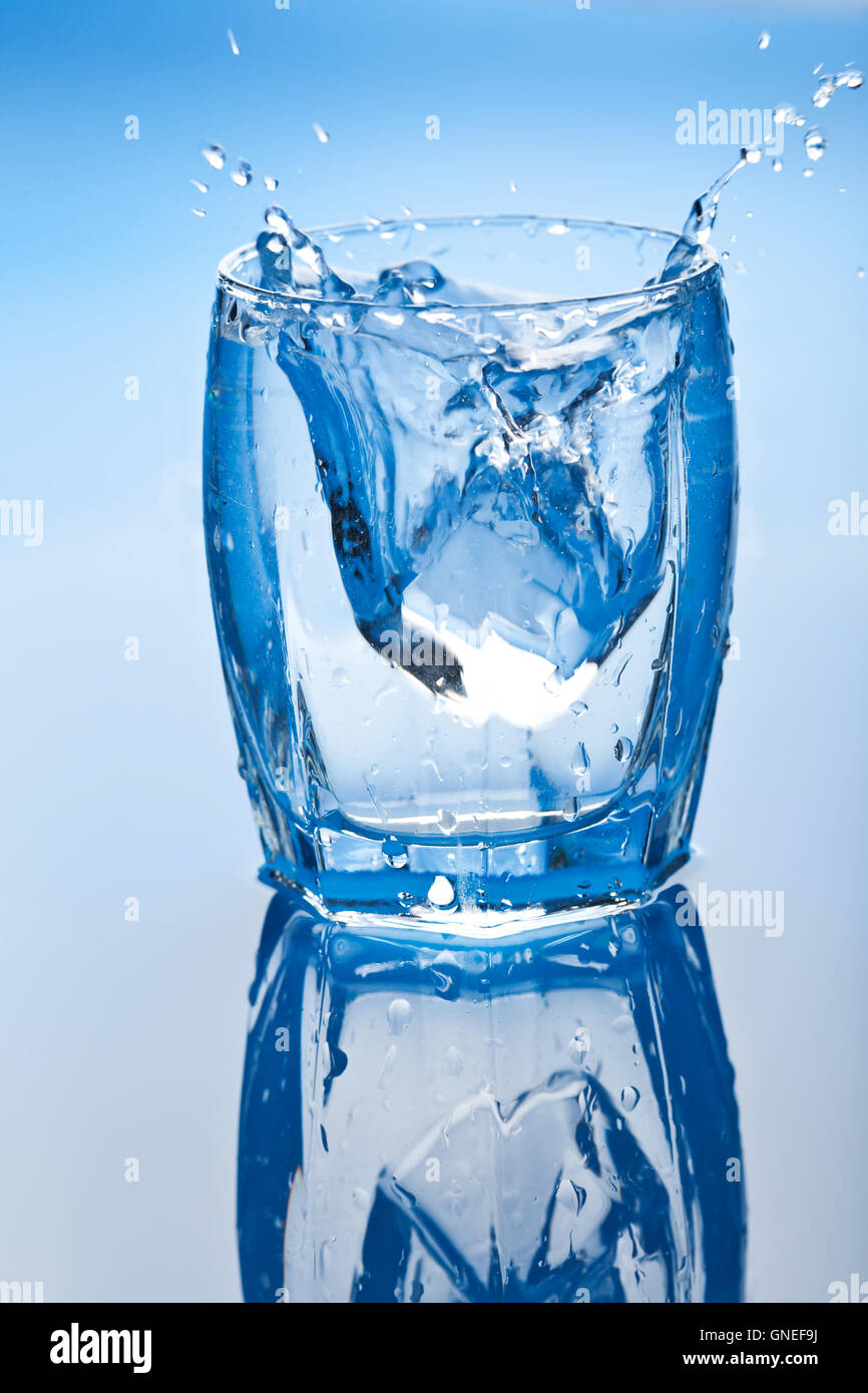 ice cube splashing into glass of water Stock Photo - Alamy